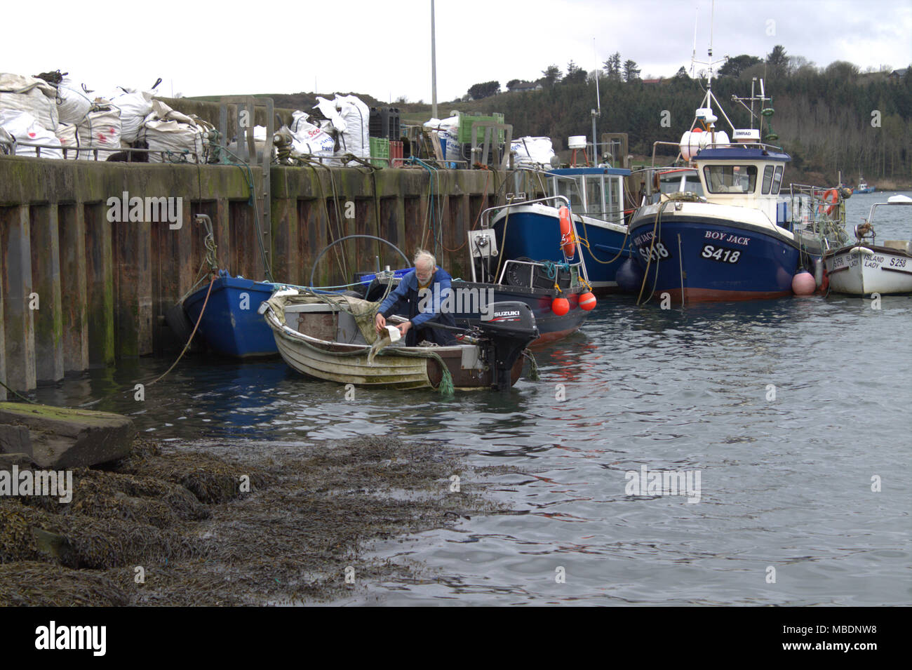 Fisherman renflouer son bateau avant de prendre la vague pour atteindre ses pots de crabe. West Cork, Irlande Banque D'Images