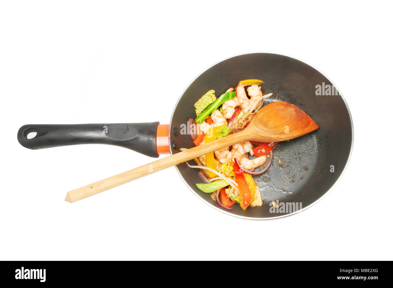 Grosses crevettes et légumes avec une cuillère en bois dans un wok isolés contre white Banque D'Images