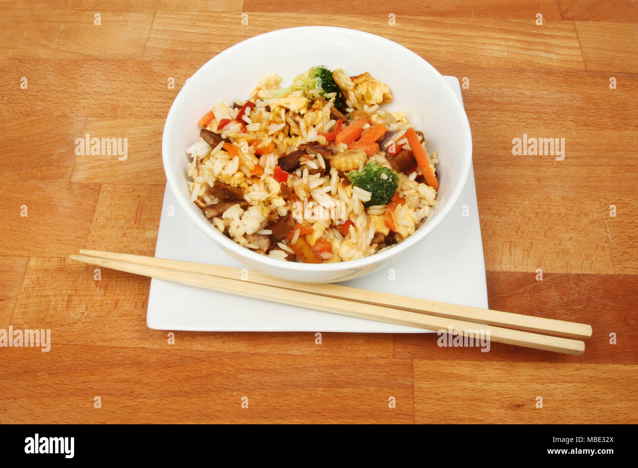 Plat de riz sautées avec des baguettes sur une table en bois Banque D'Images