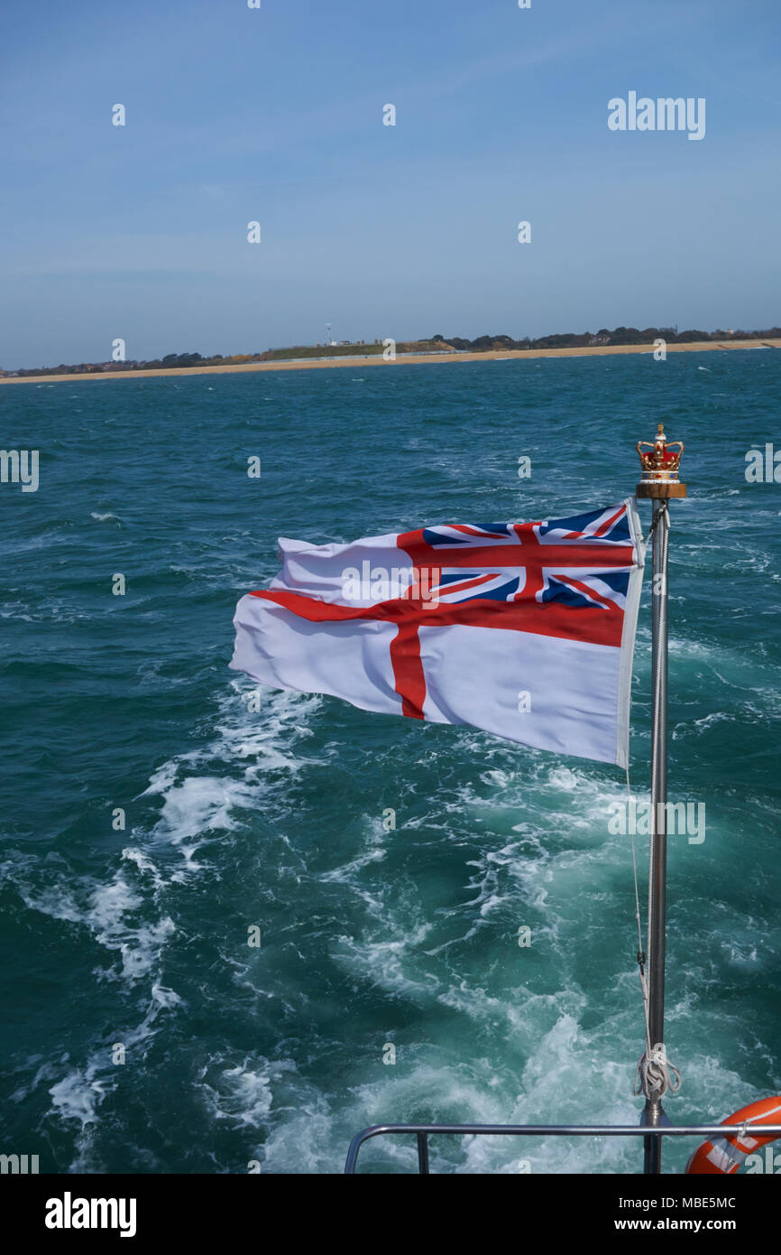 Un pavillon blanc britannique battant de l'arrière du Royal Navy HMS Dasher P2000 P280 dans la lumière du soleil Banque D'Images