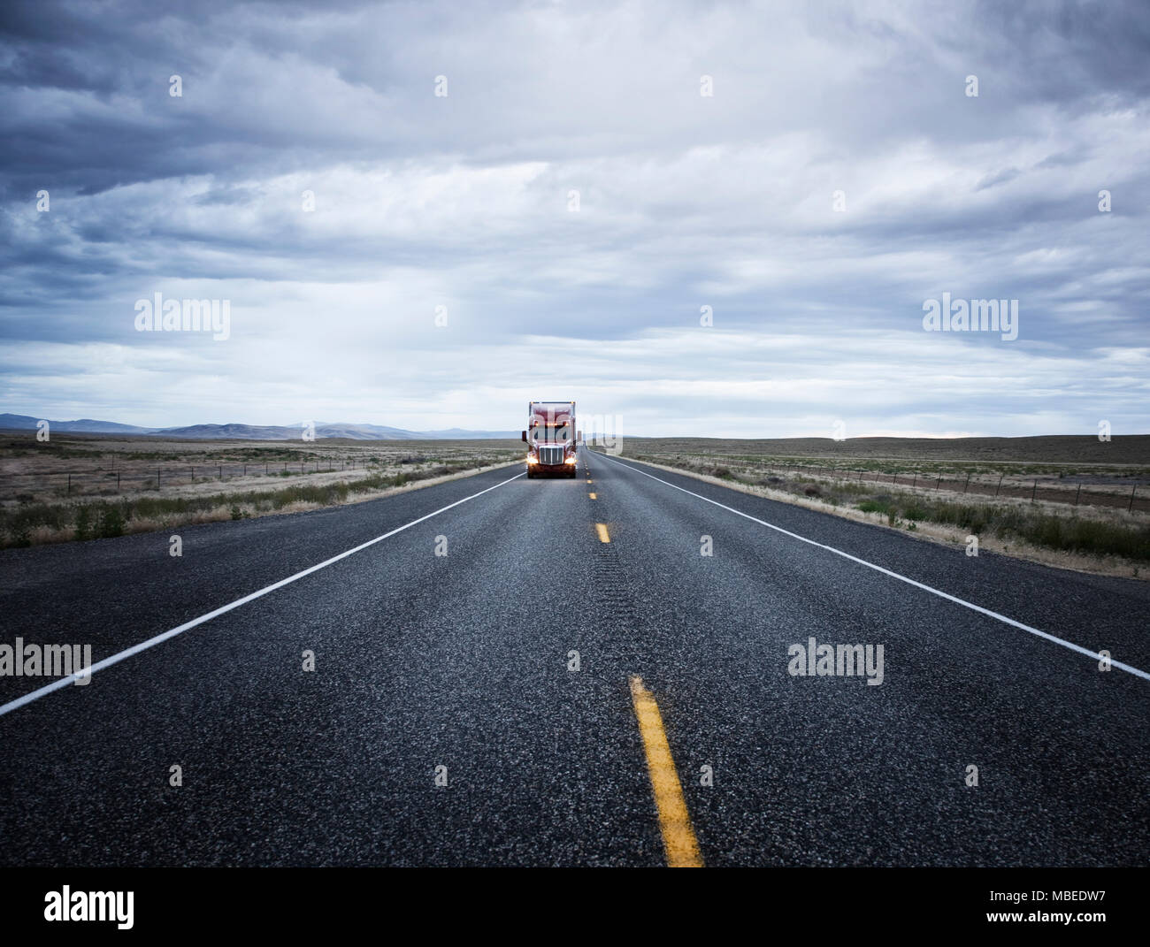 Un gros camion et remorque sur la route, en direction de la caméra, des lumières sur paysage plat, America USA Banque D'Images