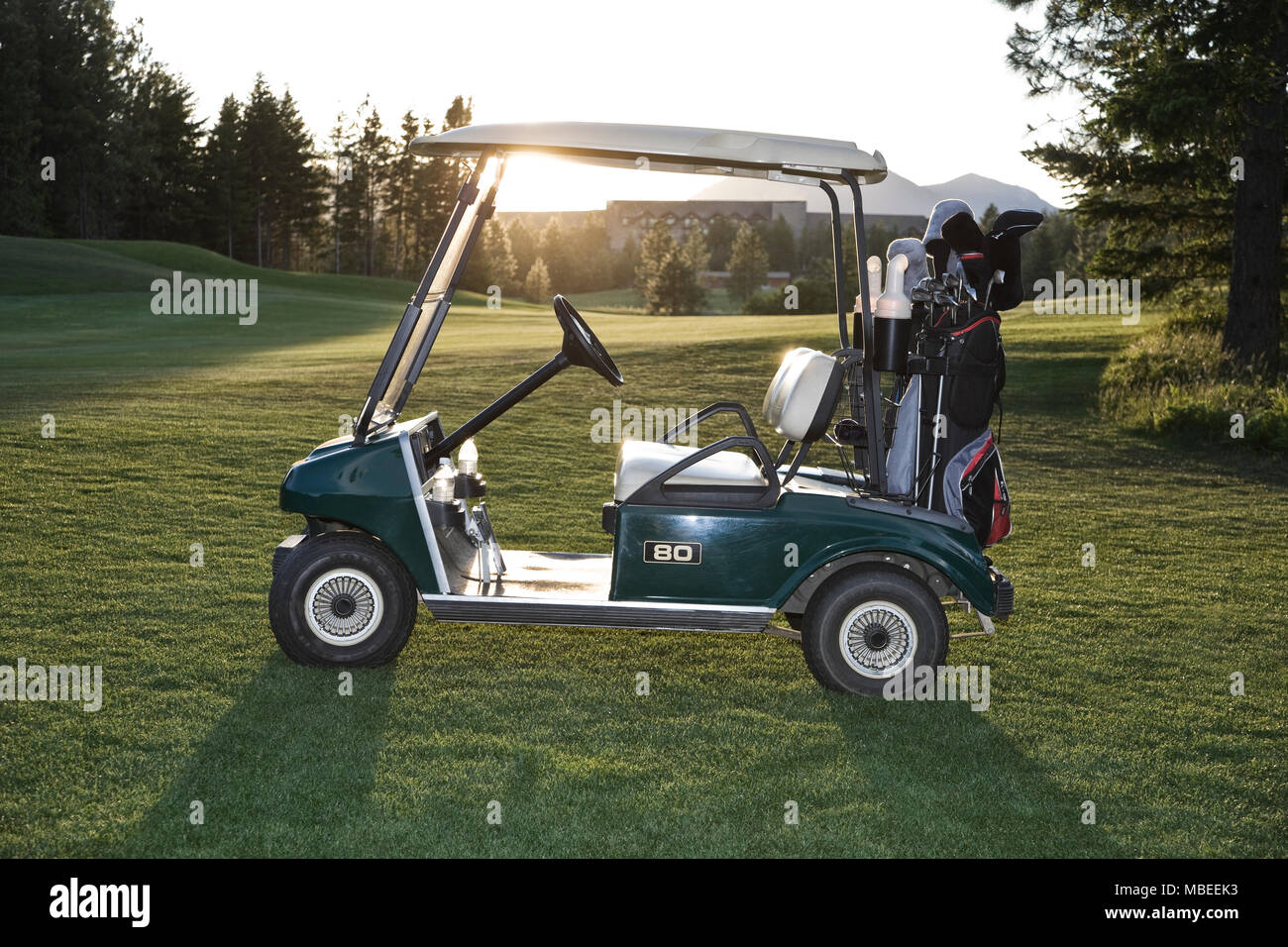 Un chariot de golf avec des sacs assis sur un terrain de golf. Banque D'Images