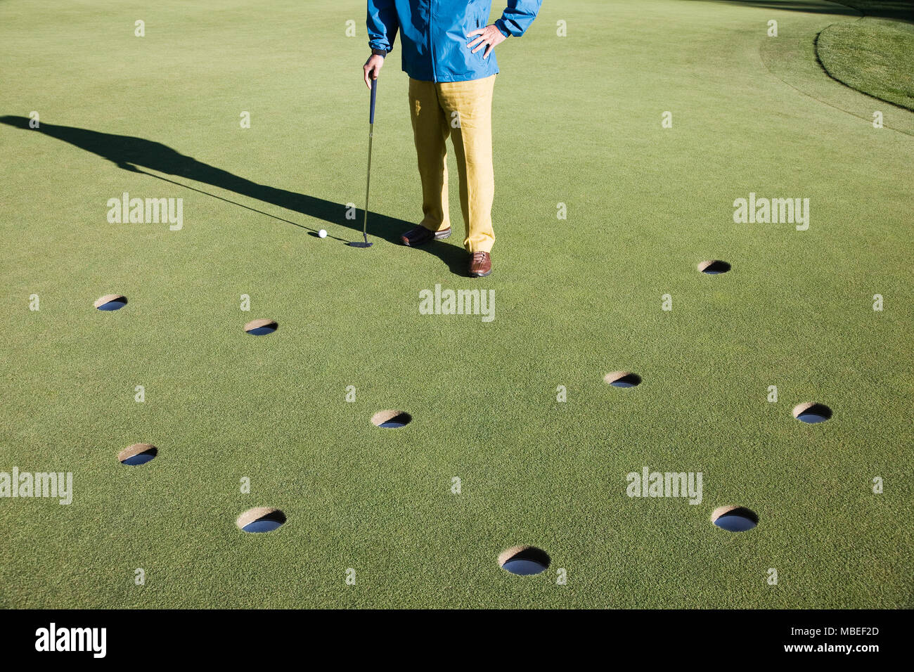 Un golfeur avec beaucoup trop de choix dans la mesure du possible les putts sur la greeen d'un terrain de golf. Banque D'Images