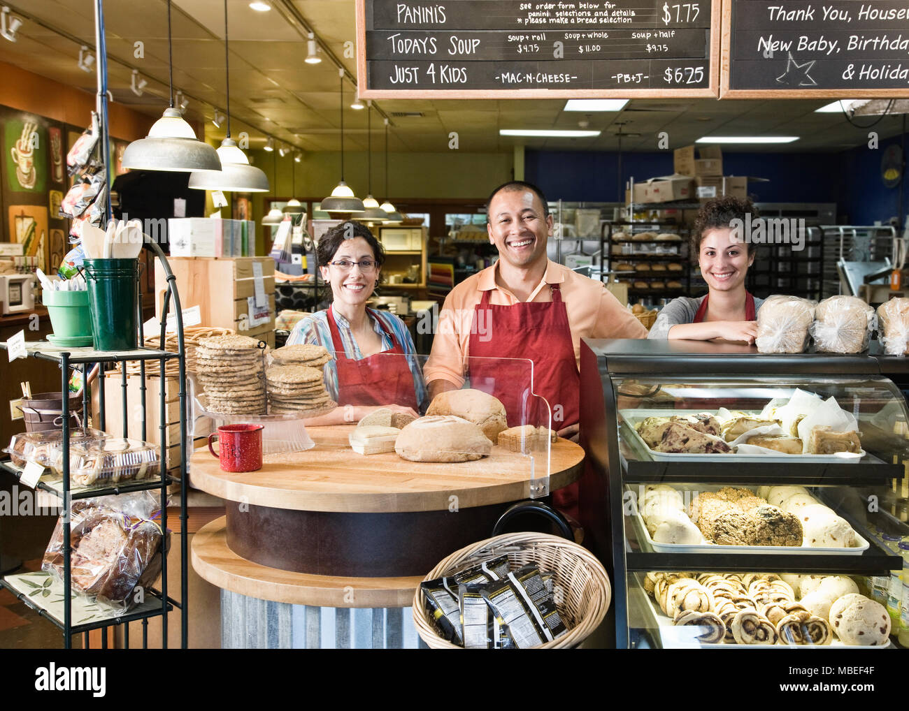 Man Baker et ses employés à la boulangerie. Banque D'Images