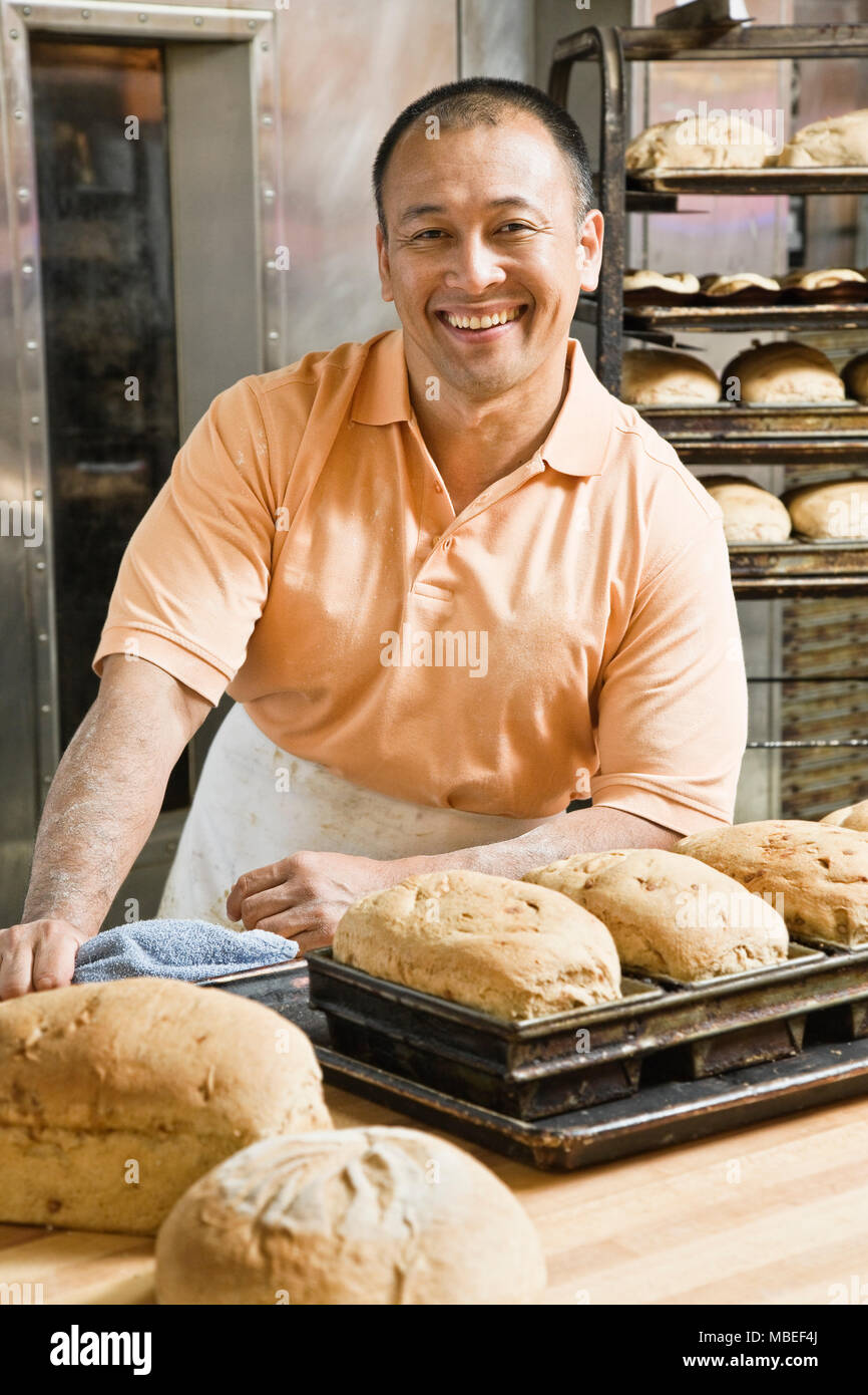 Man Baker et certains des miches de pain qu'il cuit ce matin. Banque D'Images