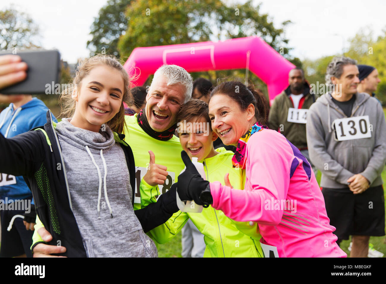 Famille enthousiaste porteur en tenant de charity race selfies Banque D'Images