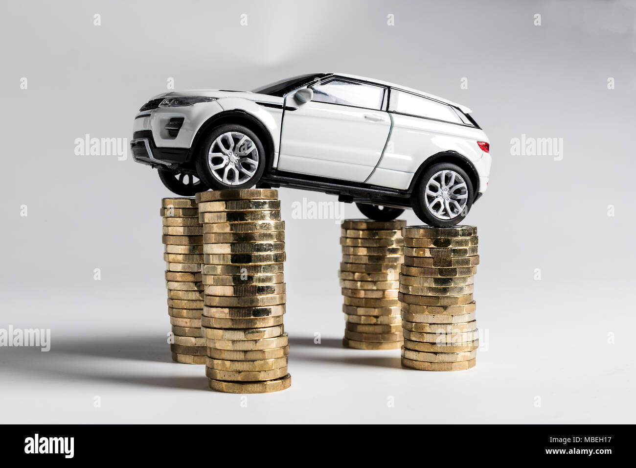 Un jouet Land Rover Evoque en équilibre sur des piles de £1 pièces. Banque D'Images