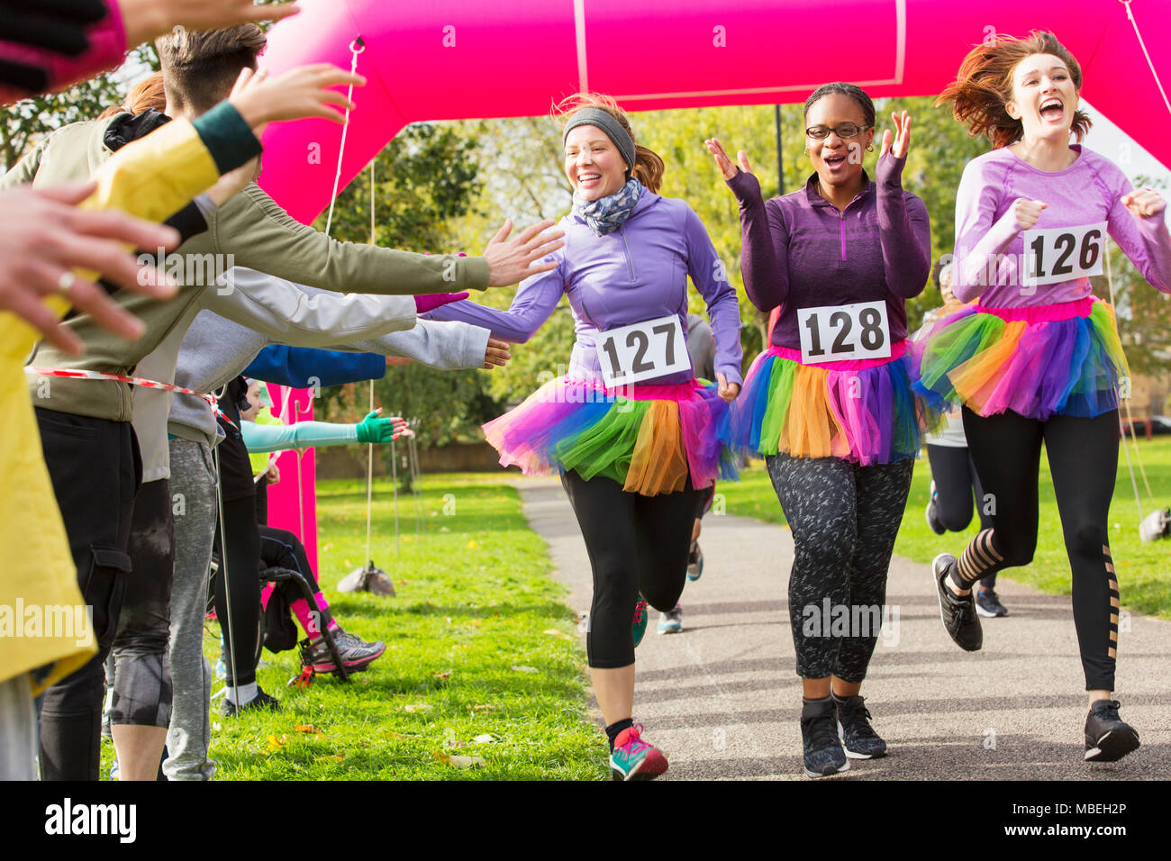 On subit donc les spectateurs des dames en tutus traversant la ligne d'arrivée course de bienfaisance Banque D'Images