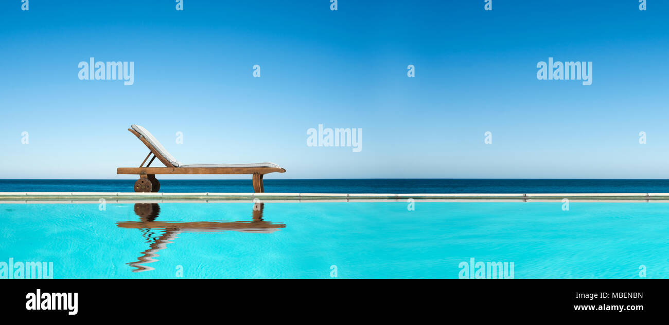 Chaise longue près d'une piscine, la mer et le ciel bleu en arrière-plan panoramique Banque D'Images