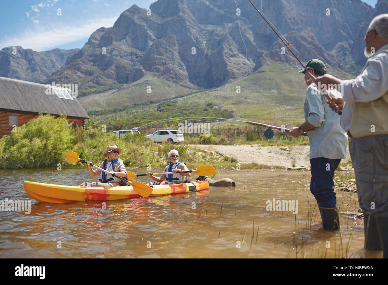 Amis senior et pêche kayak au lac d'été ensoleillé Banque D'Images