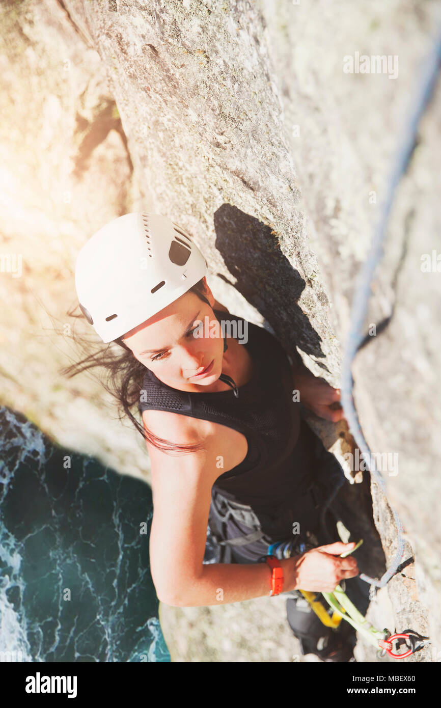 Déterminé, l'accent female rock climber scaling rock Banque D'Images