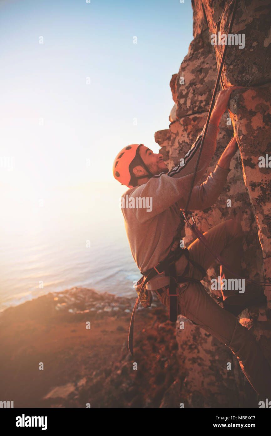 Male rock climber scaling rock Banque D'Images