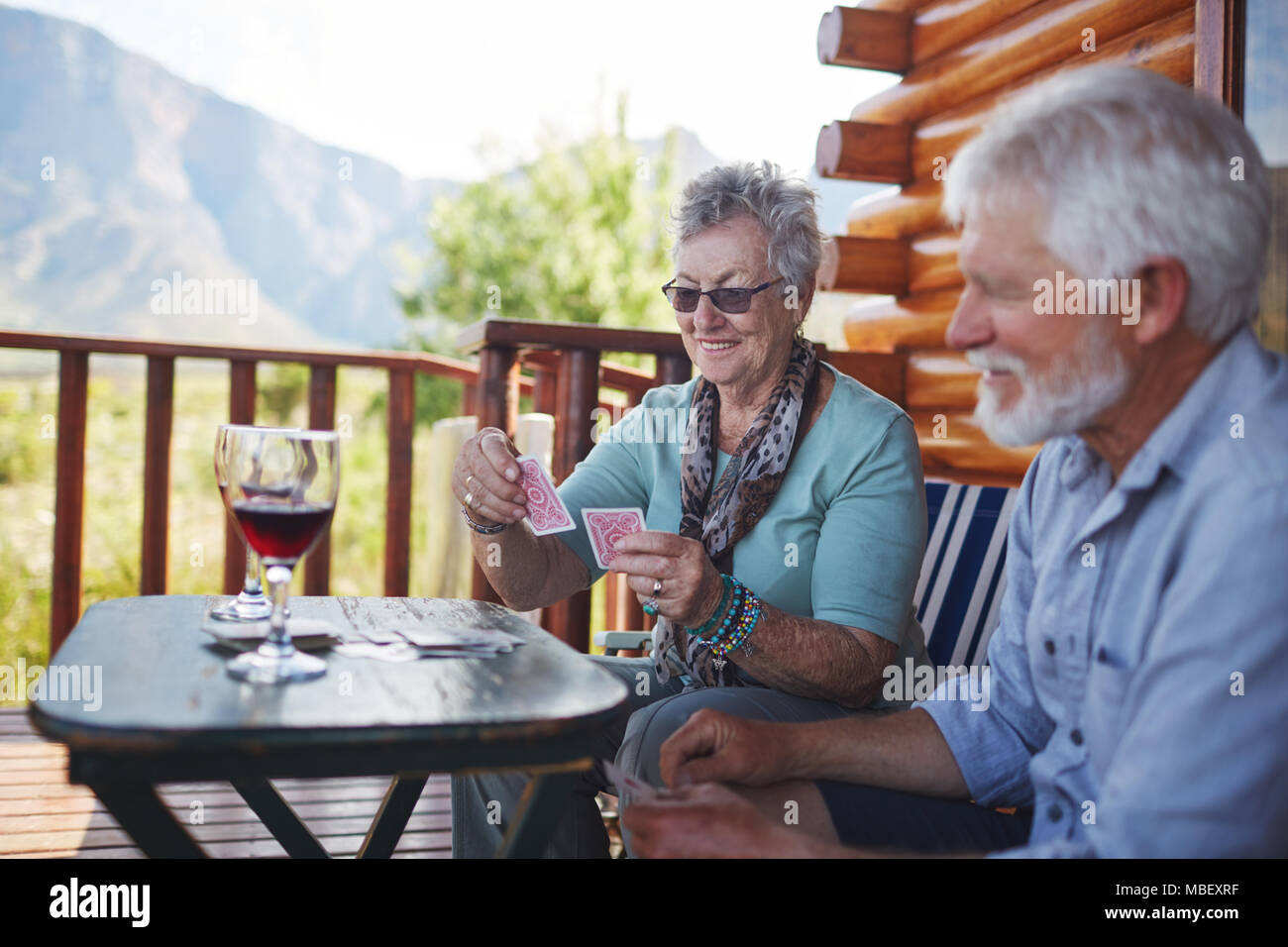 Senior couple drinking wine et de cartes à jouer sur le balcon cabine Banque D'Images