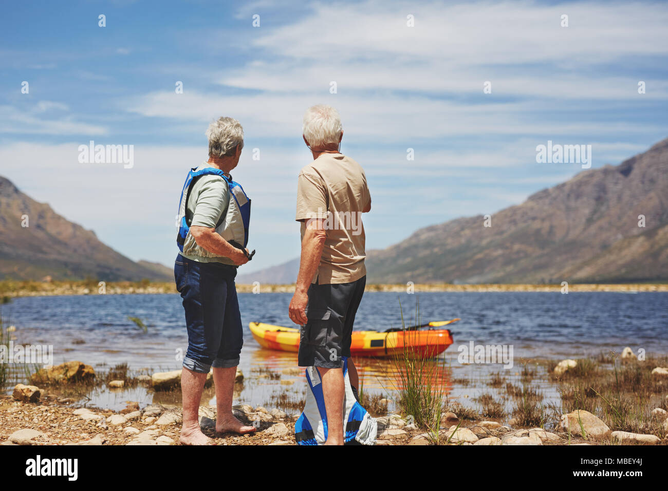 Couple actif la préparation de kayak au lac d'été ensoleillé Banque D'Images