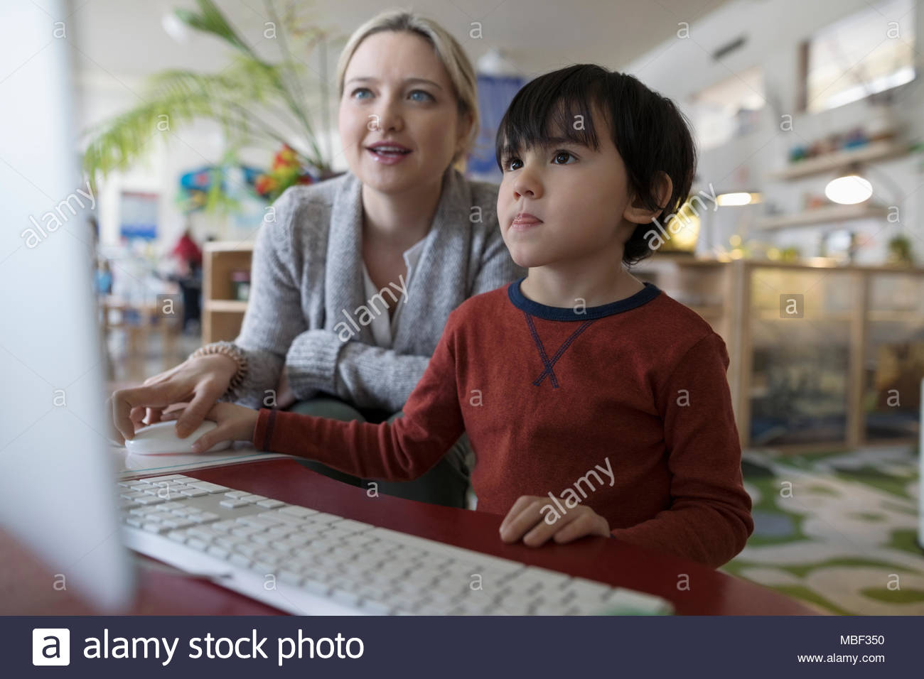 Enseignants préscolaires et le garçon à l'ordinateur Banque D'Images