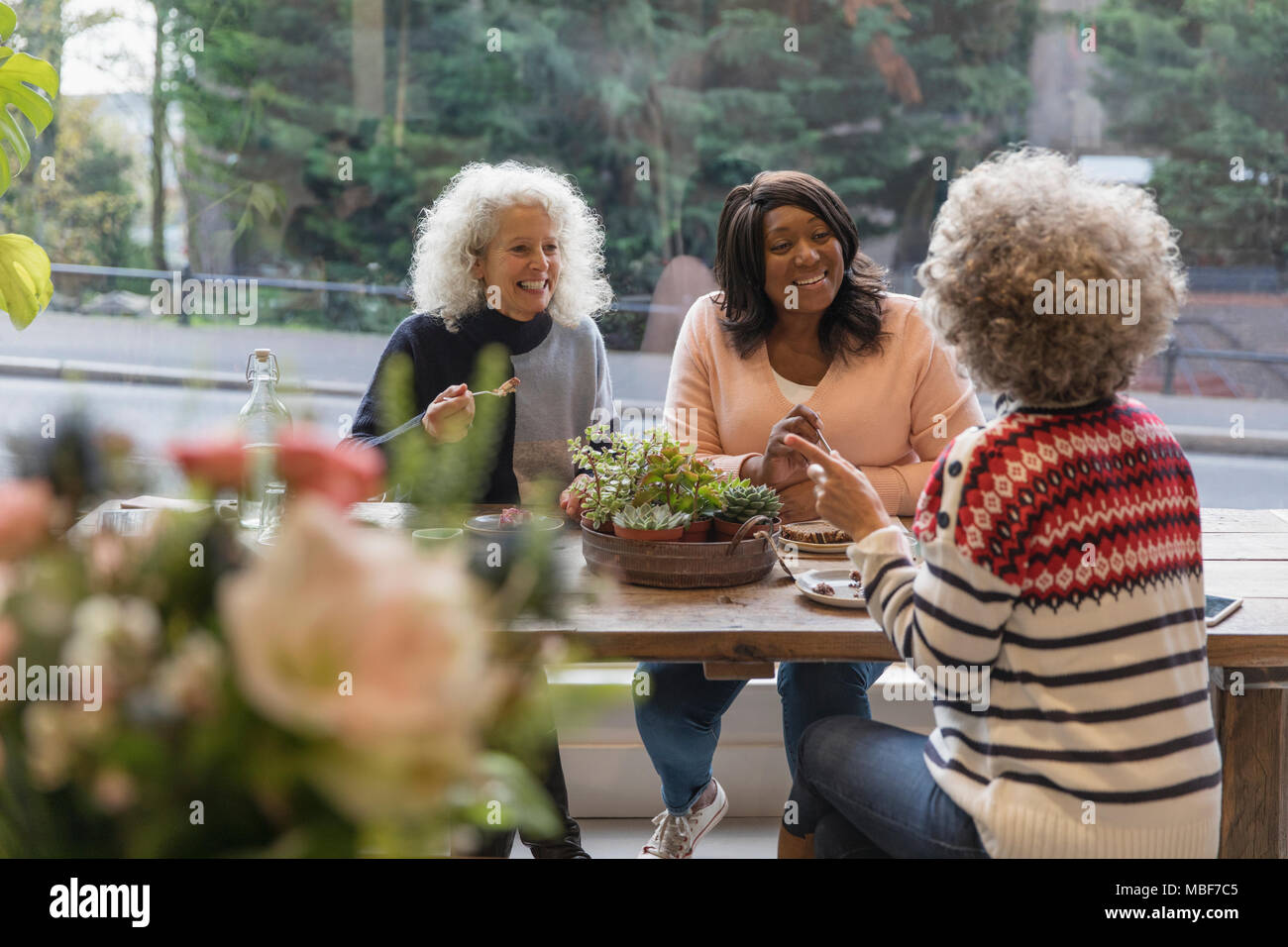 Les femmes amis parler et manger le déjeuner au café Banque D'Images