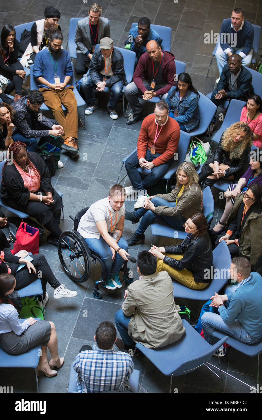 Vue de dessus femme présidente en donnant à l'auditoire de microphone en fauteuil roulant Banque D'Images