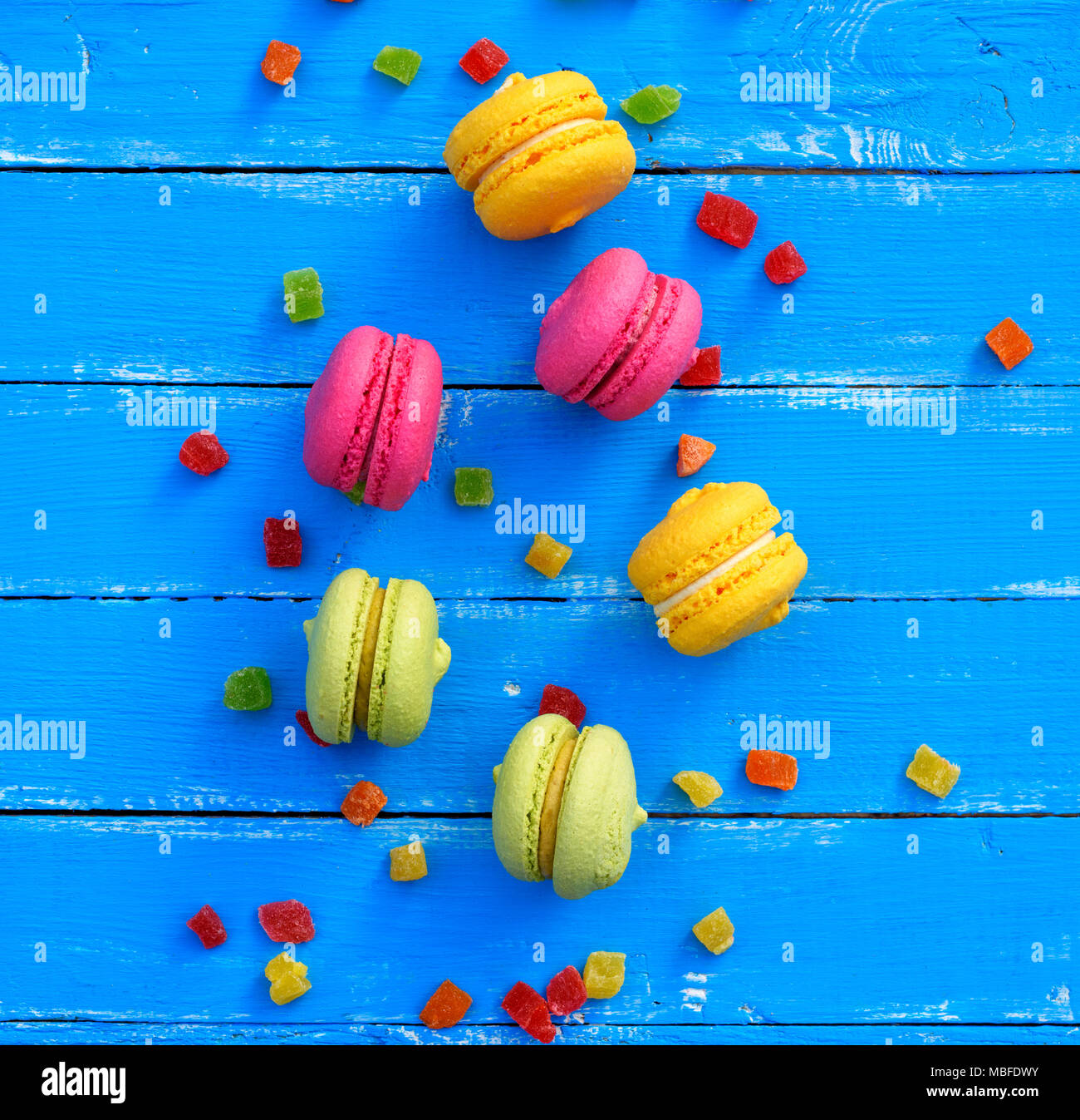 Gâteau de farine d'amande multicolores avec crème macarons sur fond bleu, macarons au milieu, vue du dessus Banque D'Images