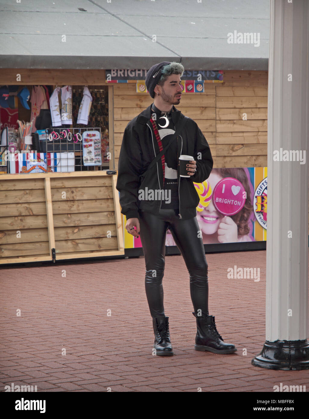 Un jeune homme en pantalon en plastique noir, boit du café à Brighton Photo  Stock - Alamy