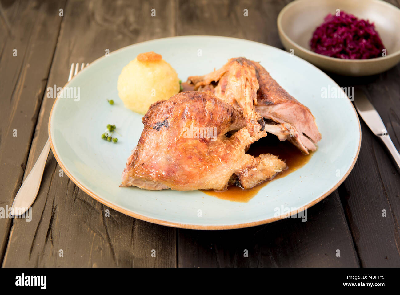 Bavarois grillé croustillant de canard avec du chou rouge et des raviolis servis dans un restaurant allemand et de l'Oktoberfest. Banque D'Images