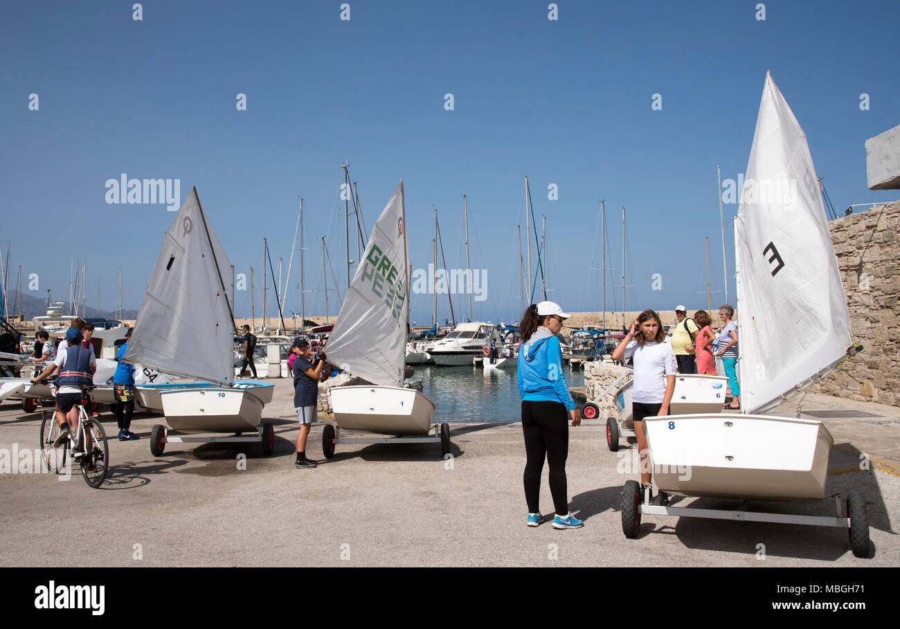 Héraklion, Crète, Grèce, 2017. Les jeunes de la préparation de leurs bateaux pour une leçon de voile dans le port d'Héraklion. Banque D'Images