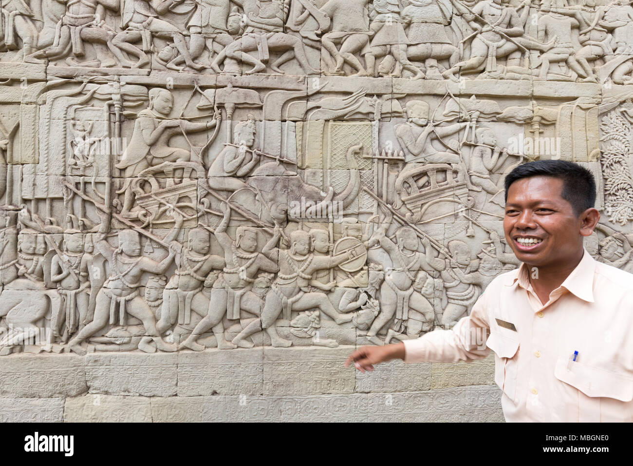 Tour guide, parlant de l'sculptures, temple Bayon, Angkor Thom, site du patrimoine mondial de l'Asie, Cambodge Banque D'Images