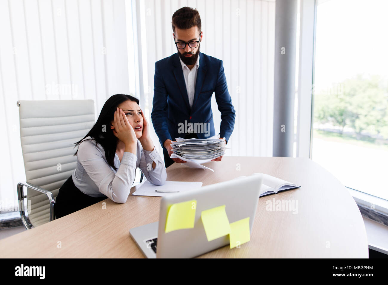 Businesswoman having maux de tête d'avoir trop de travail à faire à partir de son patron Banque D'Images