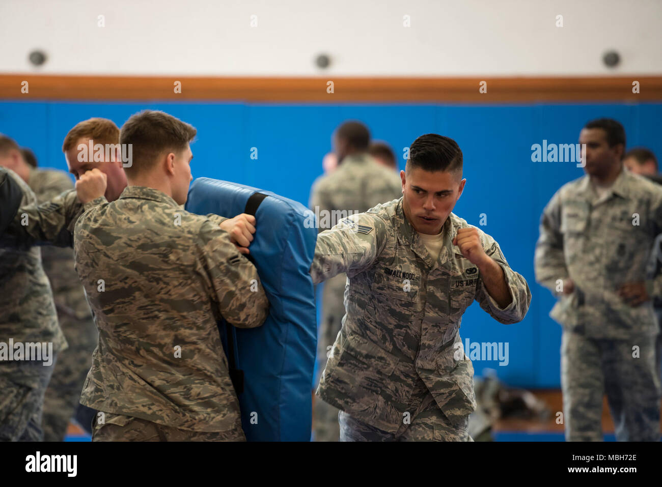 Les cadres supérieurs de l'US Air Force Airman Jared Smallwood, 18e Escadron des Forces de sécurité de chien de travail militaire, droit de grève, un sac tenu par un membre de la 1re classe Andrew Carothers, 18th FS patroller, gauche, au cours de formation combatives le 4 avril 2018, à Kadena Air Base, le Japon Membres rester physiquement résistant grâce à des cours de perfectionnement dans les techniques de combat.. Banque D'Images