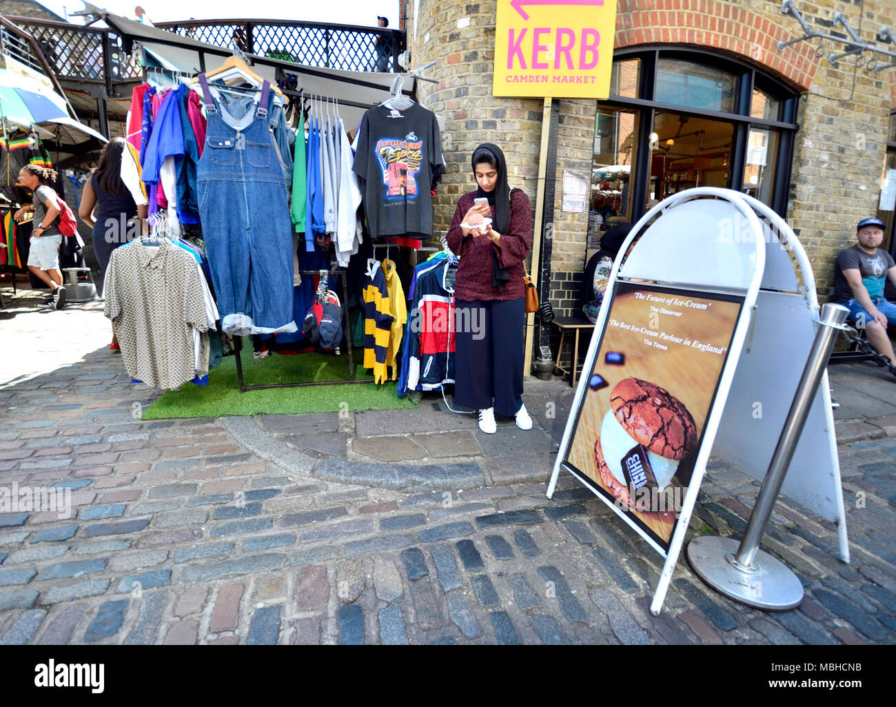 Londres, Angleterre, Royaume-Uni. Marché de Camden : Muslim woman looking at her mobile phone Banque D'Images
