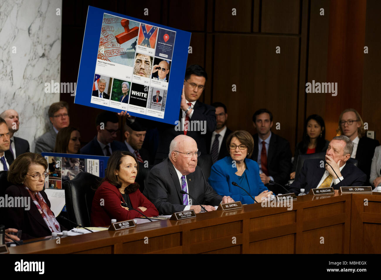 Washington, USA. 10 avr, 2018. Une aide pour le sénateur Patrick Leahy, Démocrates de New York, est titulaire d'un panneau avec de faux news articles utilisés dans l'élection présidentielle américaine de 2016 comme le sénateur demande Facebook PDG Mark Zuckerberg une question alors qu'il témoigne devant le Sénat des États-Unis sur la colline du Capitole à Washington, DC Le 10 avril 2018. Crédit : l'accès Photo/Alamy Live News Banque D'Images