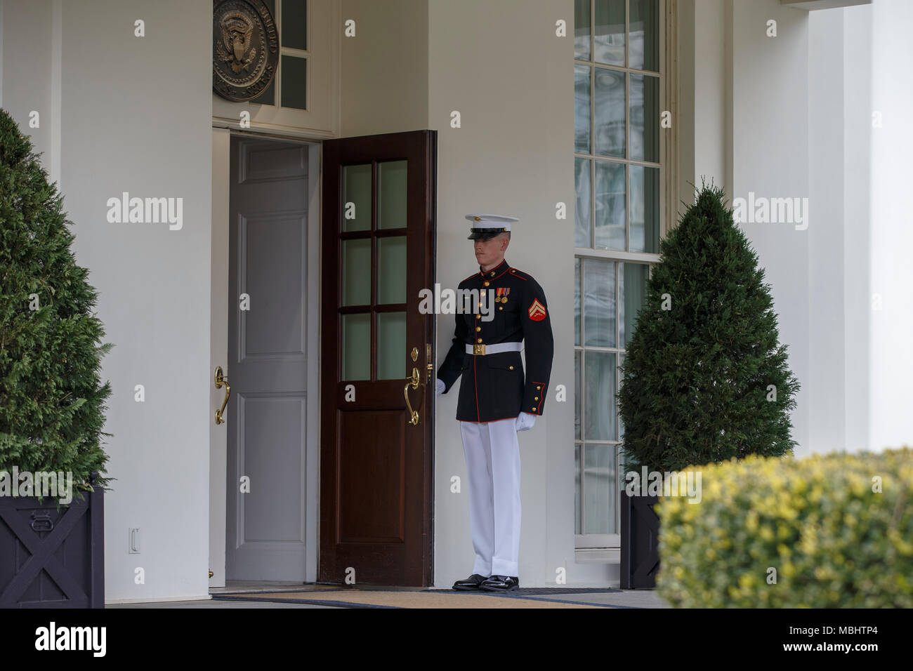 Un Marine américain maintient la porte ouverte alors qu'il monte la garde à l'extérieur de l'aile ouest de la Maison Blanche à Washington, DC Le 11 avril 2018. Crédit : Alex Edelman/CNP /MediaPunch Banque D'Images
