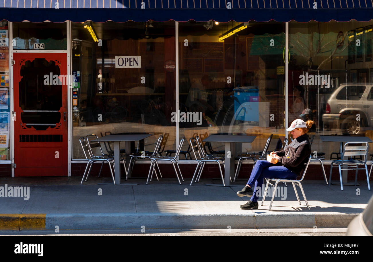 Femme appréciant le déjeuner au soleil à l'extérieur de Sweetie's Deli ; District historique national ; Salida, Colorado, USA Banque D'Images