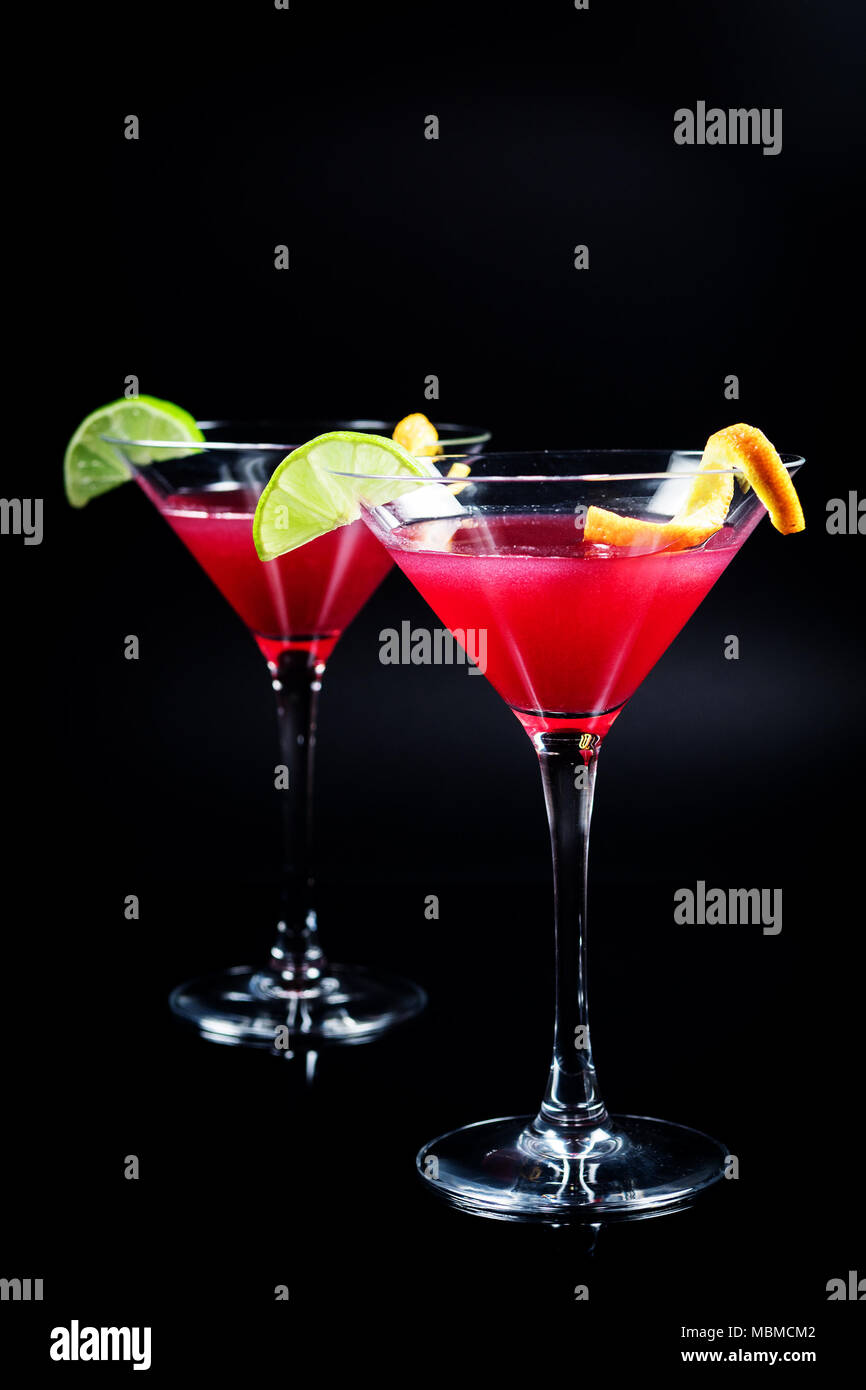 Boire de l'alcool cocktail Cosmopolitan avec de la chaux sur fond noir Banque D'Images