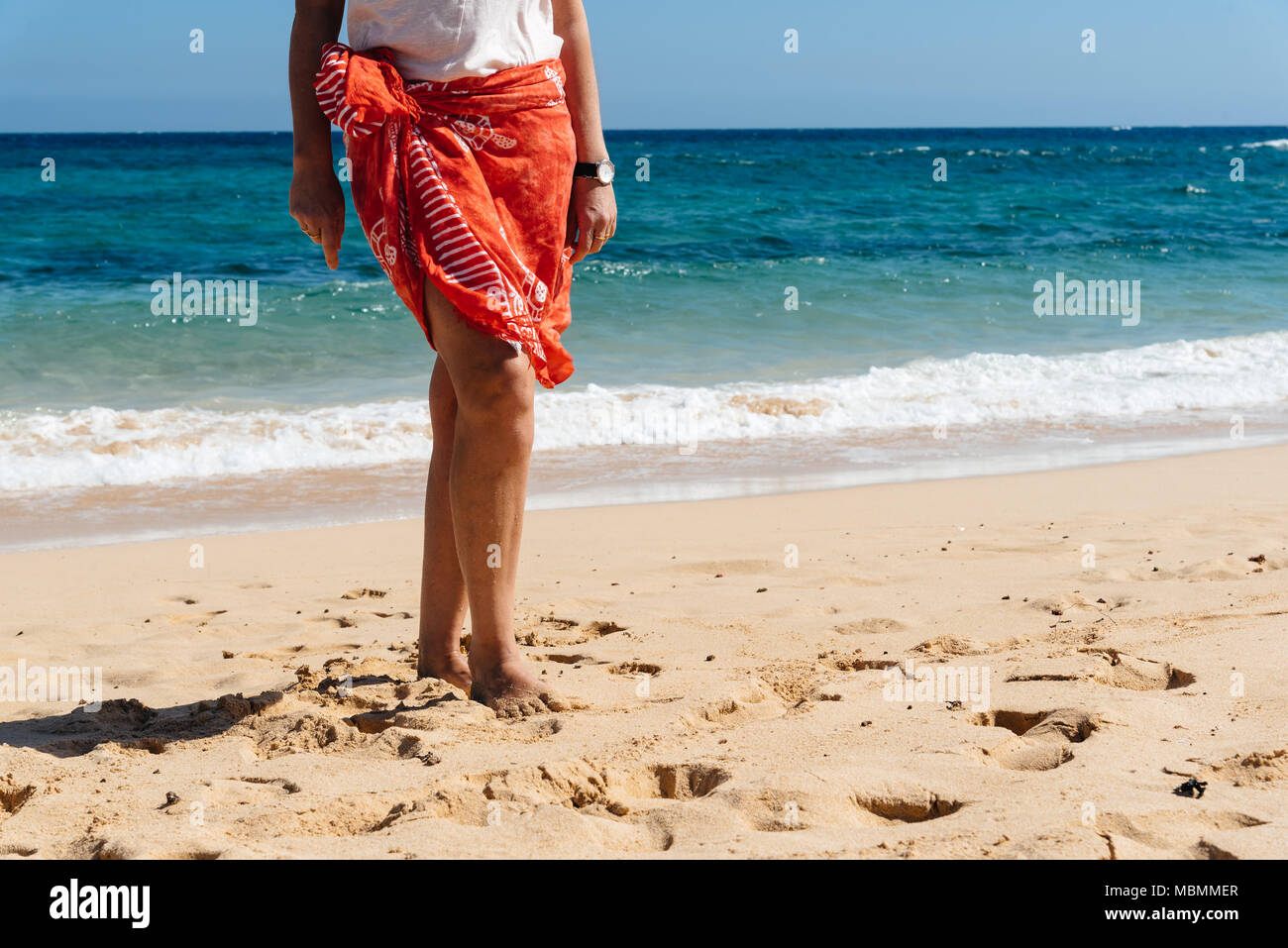 Beach Vacation Travel, jambes femme libre debout sur la plage de sable blanc en relaxant paréo camouflage vêtements de plage. Vacances d'été, la perte de poids concept. Banque D'Images