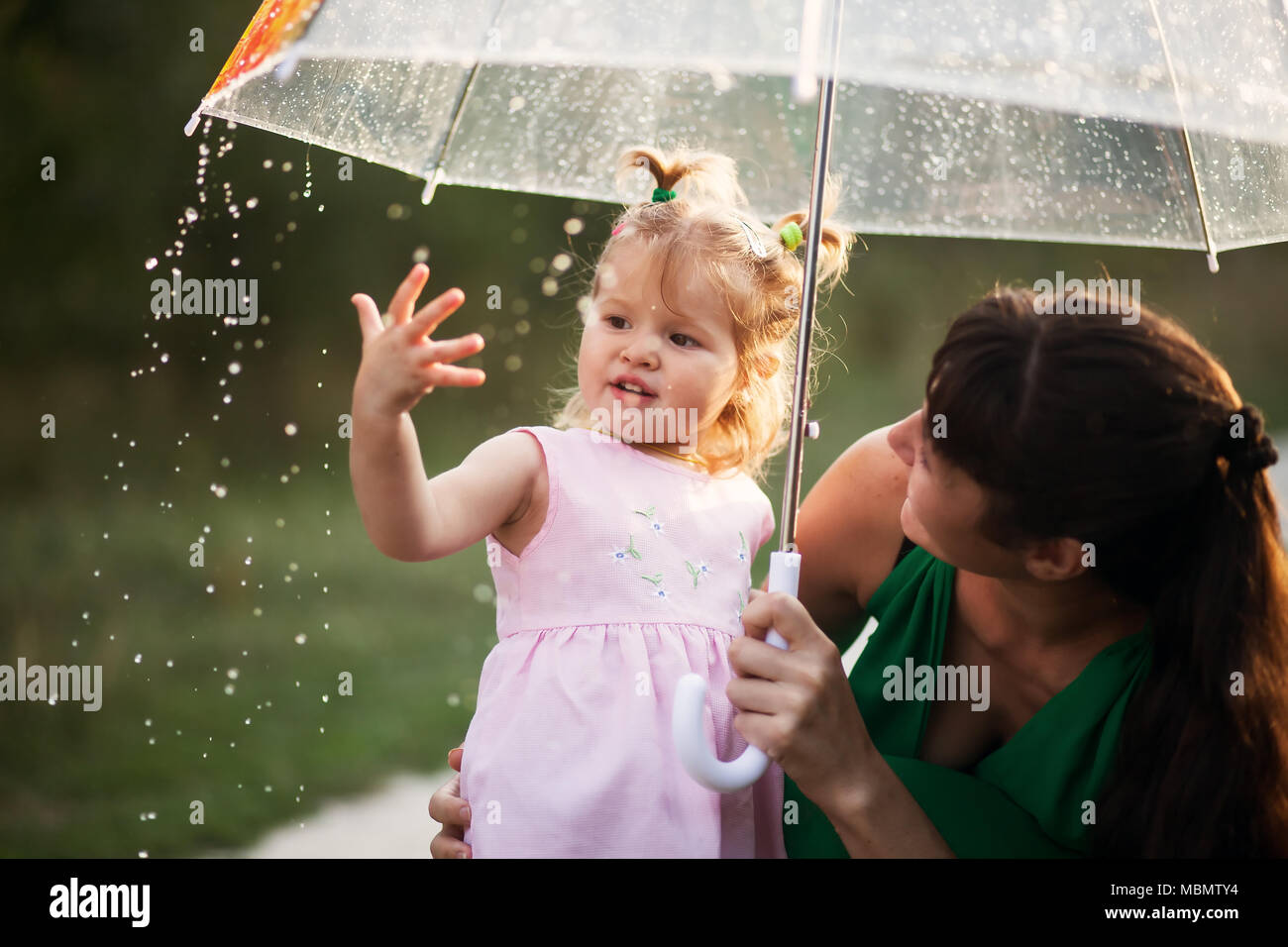 Drole De Famille Heureuse Fille Et Sa Mere Sont Beneficiant De Precipitations Kid Et Maman Jouent Sur La Nature A L Exterieur La Fille Revele Sur La Pluie Et Le Sourire Photo Stock