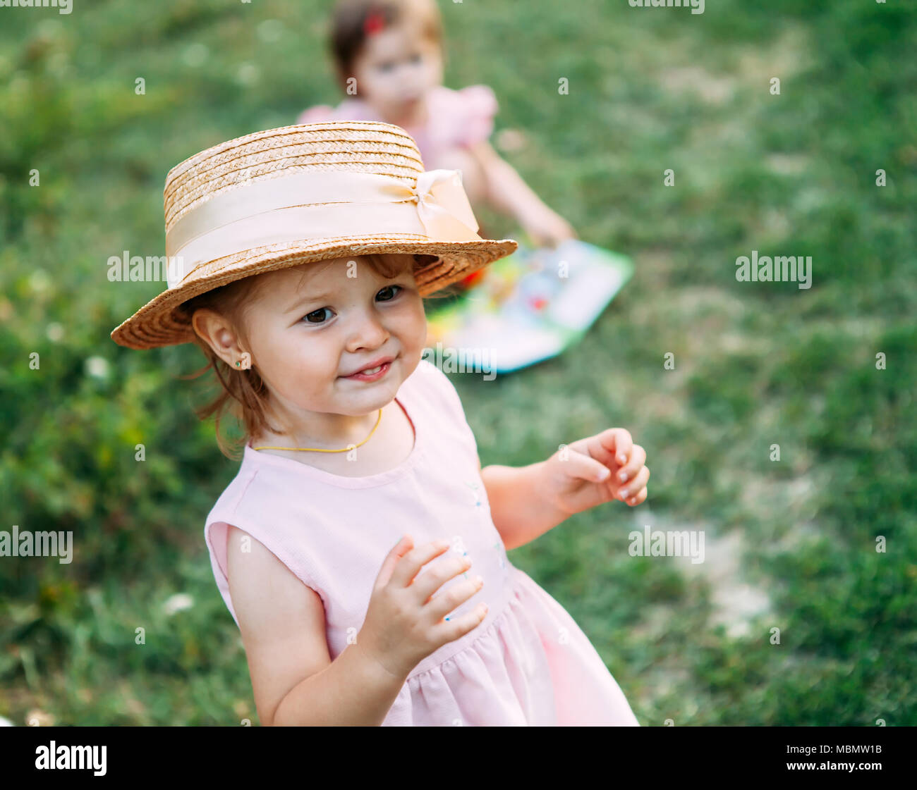 Les petites filles jouent dans la nature cute baby girl portrait.petite fille dans un chapeau de paille sourit un espace réservé au texte Banque D'Images