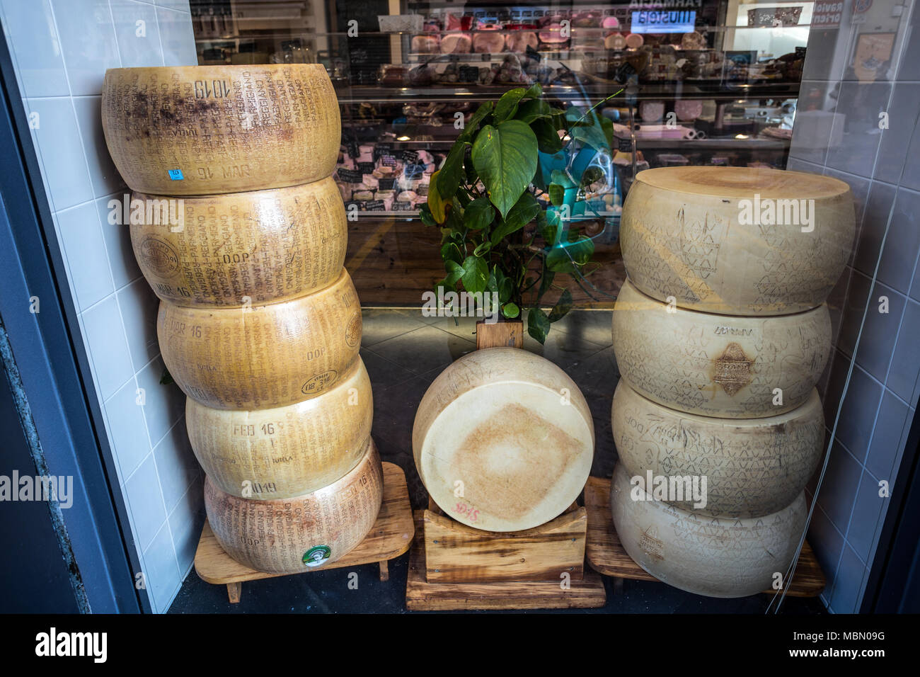 Gênes, Italie, le 5 avril 2018 - formes empilées Parmigiano Reggiano, le plus célèbre fromage italien en vente dans un magasin. Banque D'Images