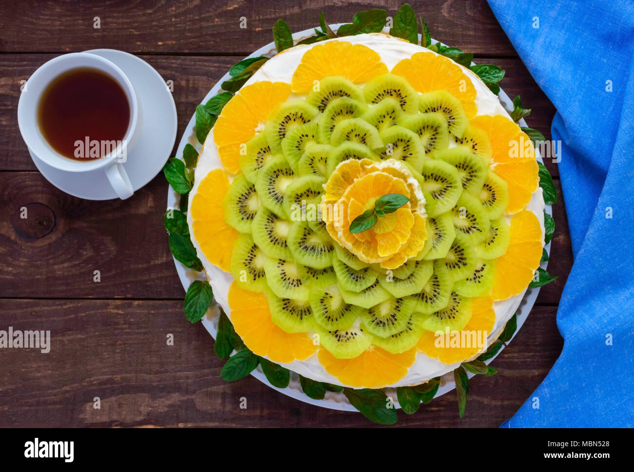 Ronde Des Fruits Lumineux De Fete Gateau Decore Avec Kiwi Orange Menthe Et D Une Tasse De The Photo Stock Alamy