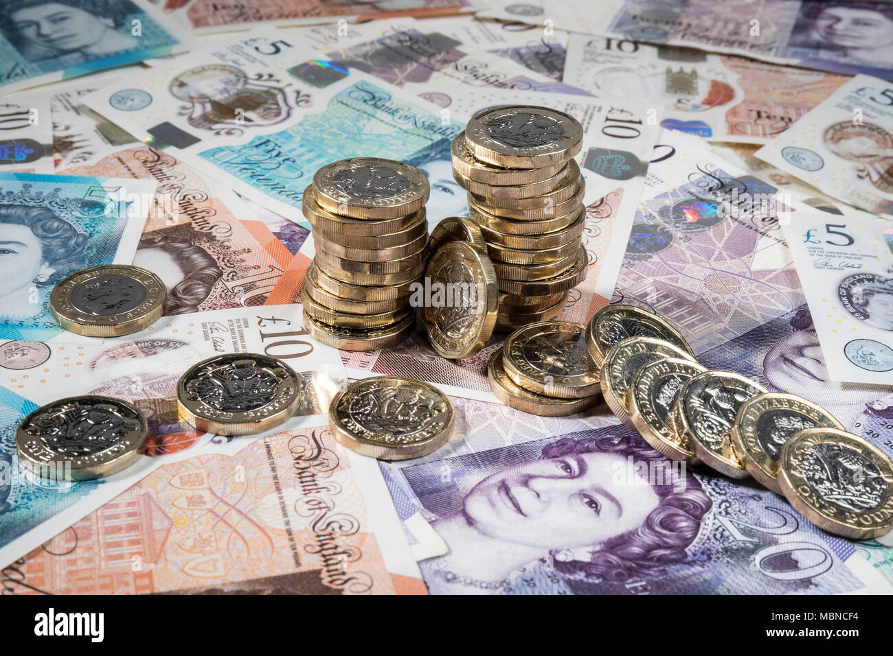 €1 pièces placées aléatoirement sur UK £5, £10, £20 et note Banque D'Images