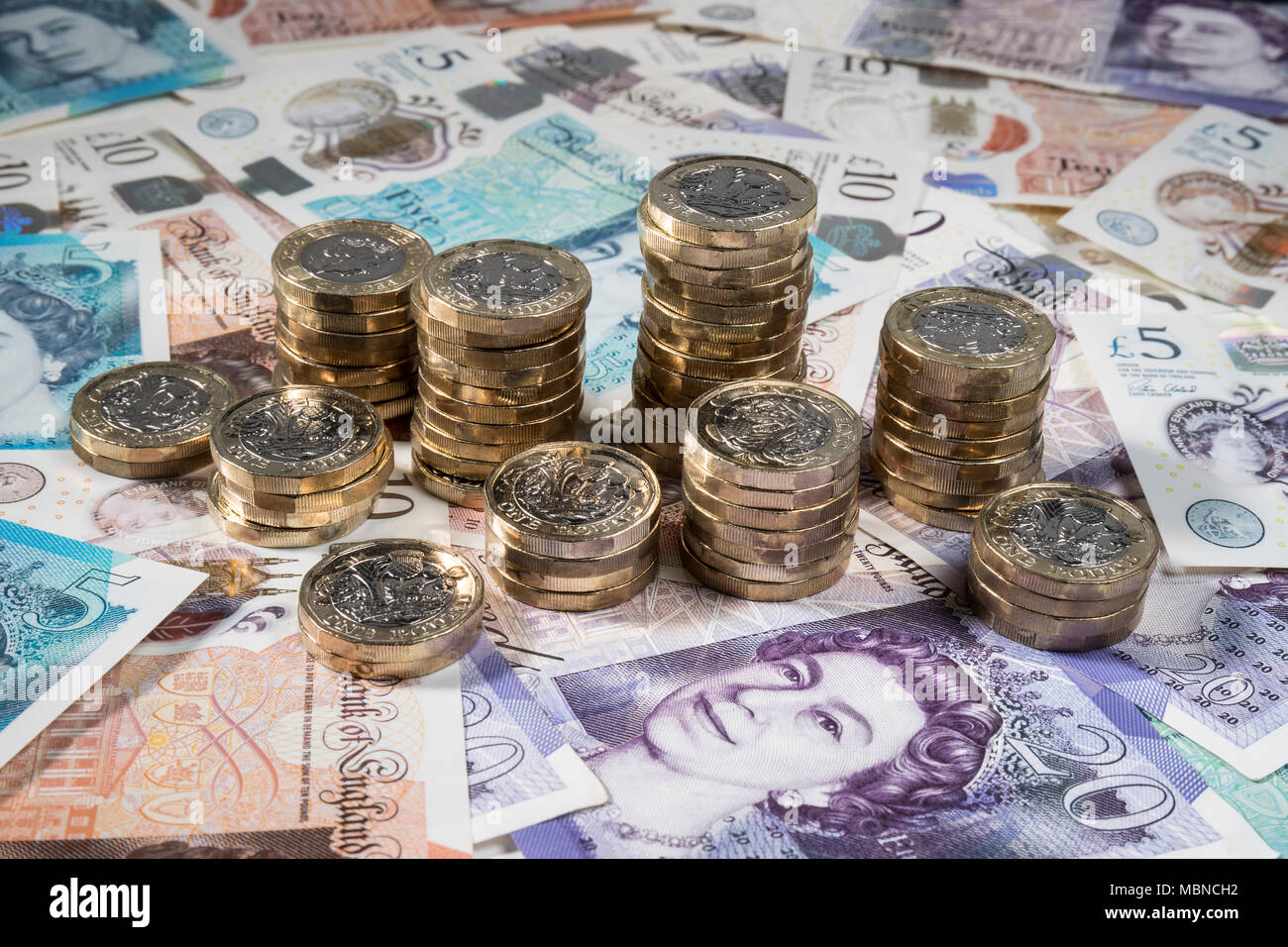 €1 pièces placées aléatoirement sur UK £5, £10, £20 et note Banque D'Images