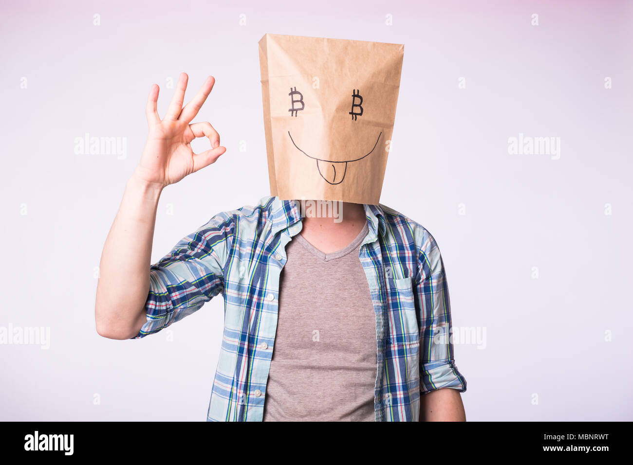 Cryptocurrency, émotion, l'exploitation minière et de l'argent concept - Homme avec boîte en carton sur la tête avec des photo de symbole bitcoin au lieu des yeux Banque D'Images