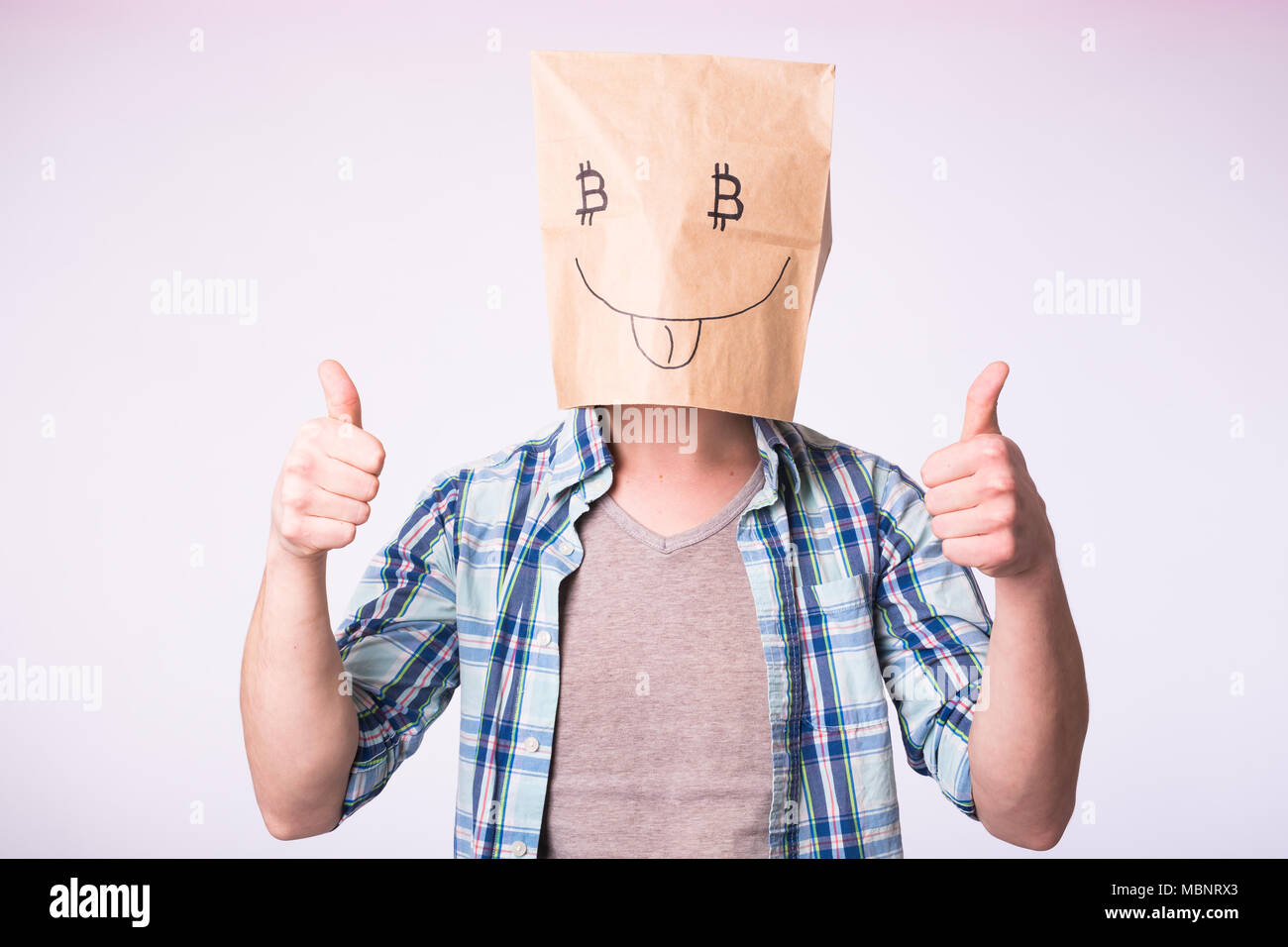 Cryptocurrency, émotion, l'exploitation minière et de l'argent concept - Homme avec boîte en carton sur la tête avec des photo de symbole bitcoin au lieu des yeux Banque D'Images