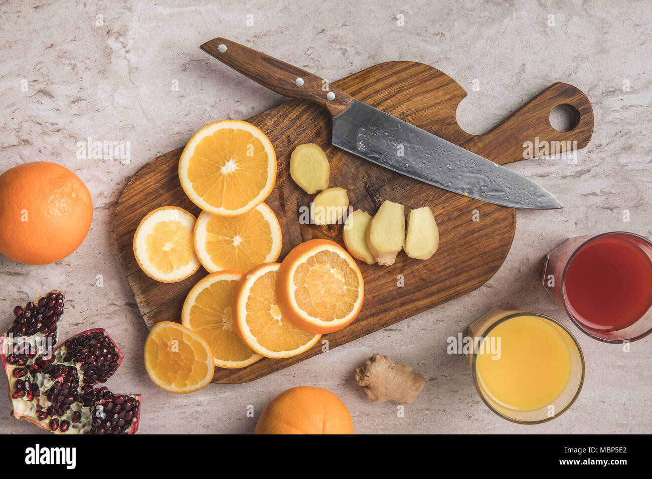 Vue de dessus de couper les oranges, de gingembre et de grenade avec des jus de fruits sur la table Banque D'Images