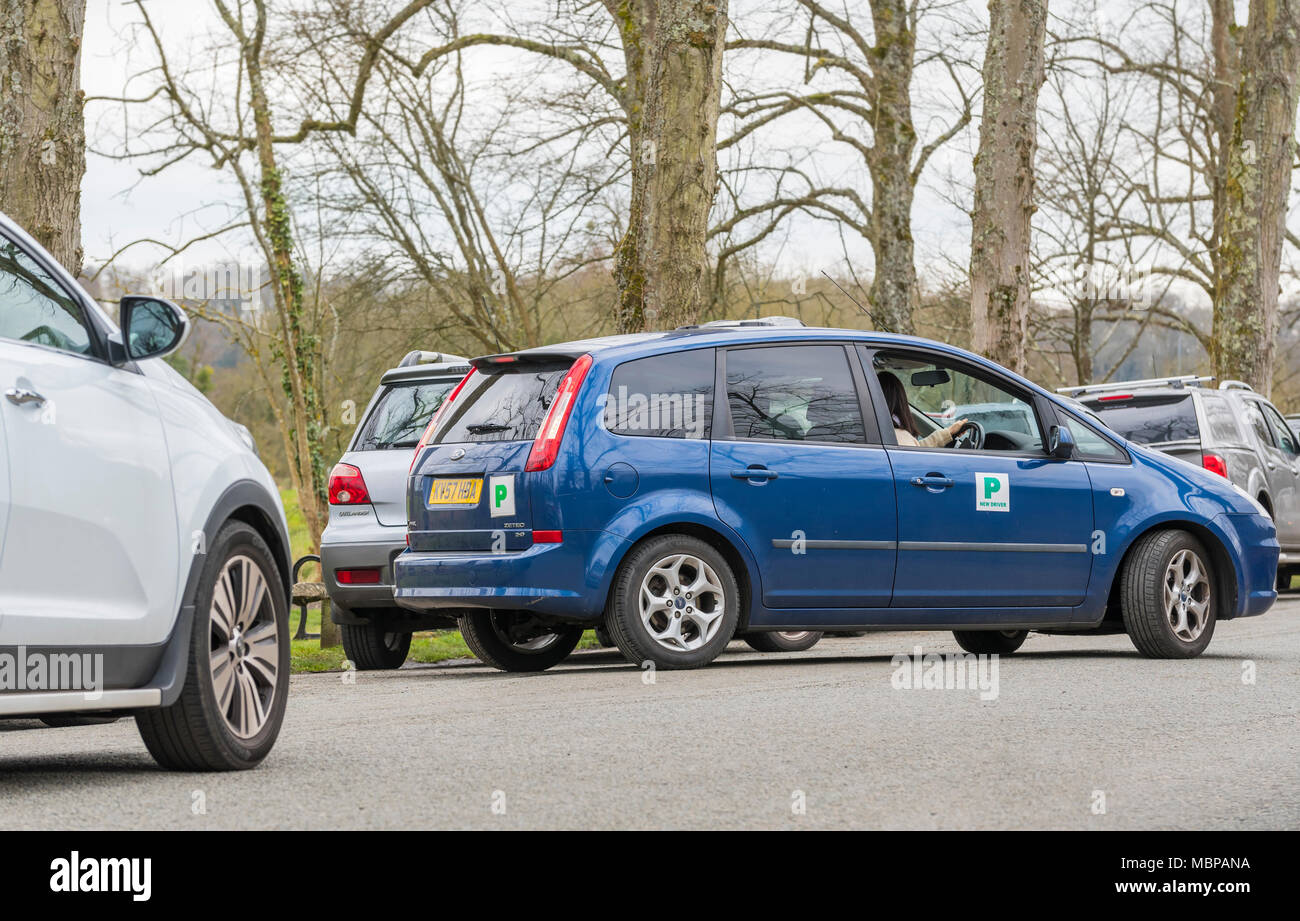 Nouveau permis probatoire affichage plaques 'P' sur une voiture, la marche arrière dans un petit parking gap en Angleterre, Royaume-Uni. Banque D'Images