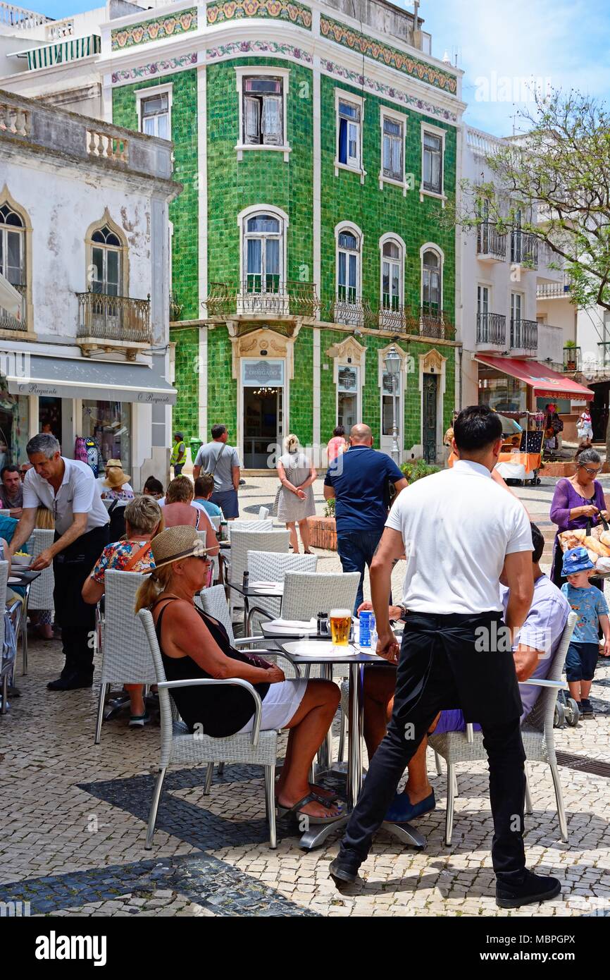 Les touristes se reposent au terrasses des cafés dans le Praca Luis de Camoes avec un sol carrelé vert bâtiment traditionnel portugais à l'arrière, Lagos, Algarve, Portug Banque D'Images