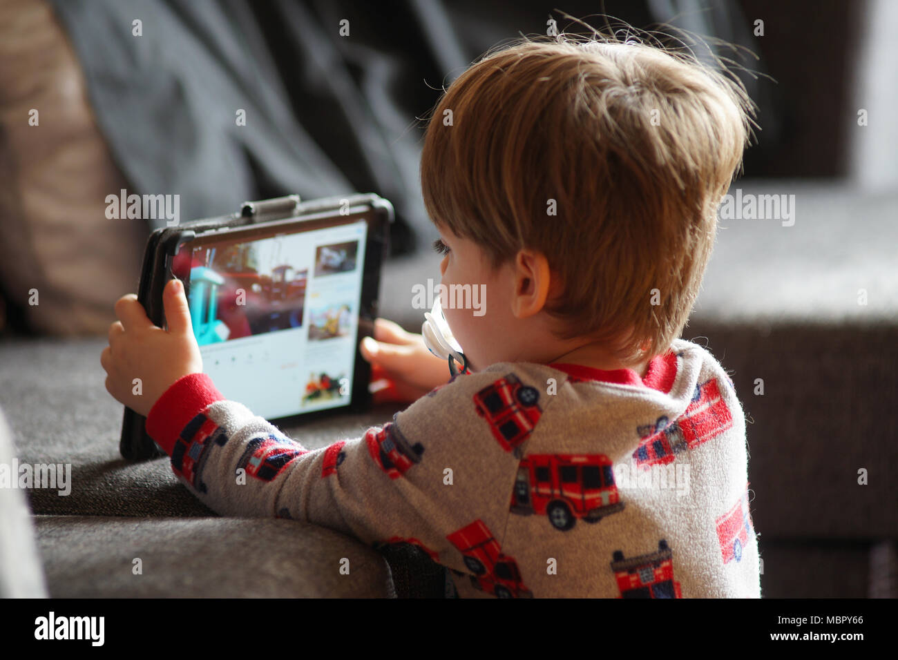Montréal,Canada,9,avril,2018.Le jeune enfant face à une tablette électronique sur canapé.Credit:Mario Beauregard/Alamy Live News Banque D'Images