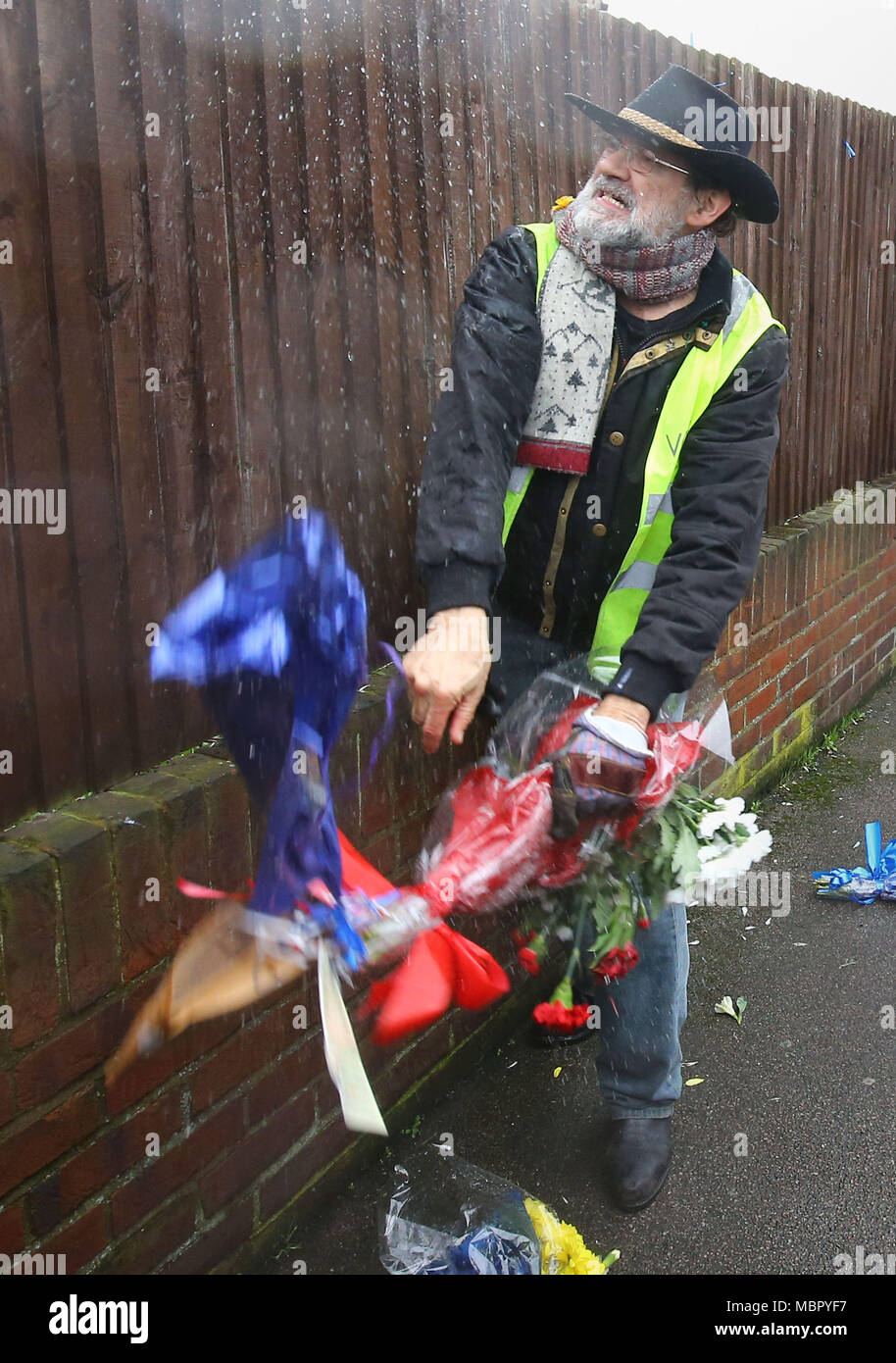 Iain Gordon tire les fleurs en baisse par une clôture en face de la maison de Richard Osborn-Brooks in South Park Crescent ici Green, Londres, après il est devenu un peu probable de l'explosion de tensions entre la famille et ses voisins depuis l'incident tragique de la semaine dernière après burglar Henry Vincent a été tué par Richard Osborn-Brooks sur sa maison. Banque D'Images