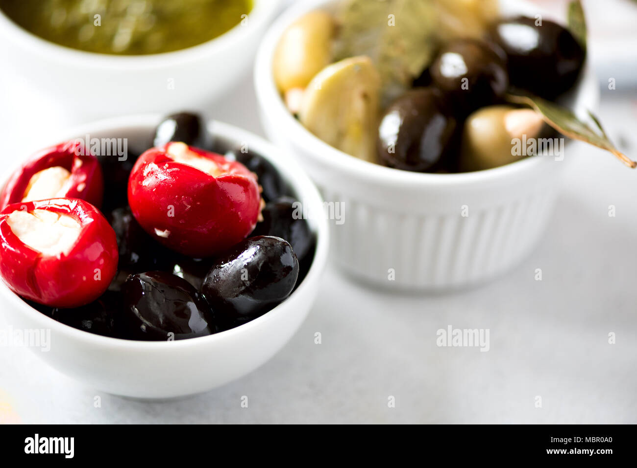 Olives et tomates à la feta en boules blanches sur fond gris. Banque D'Images