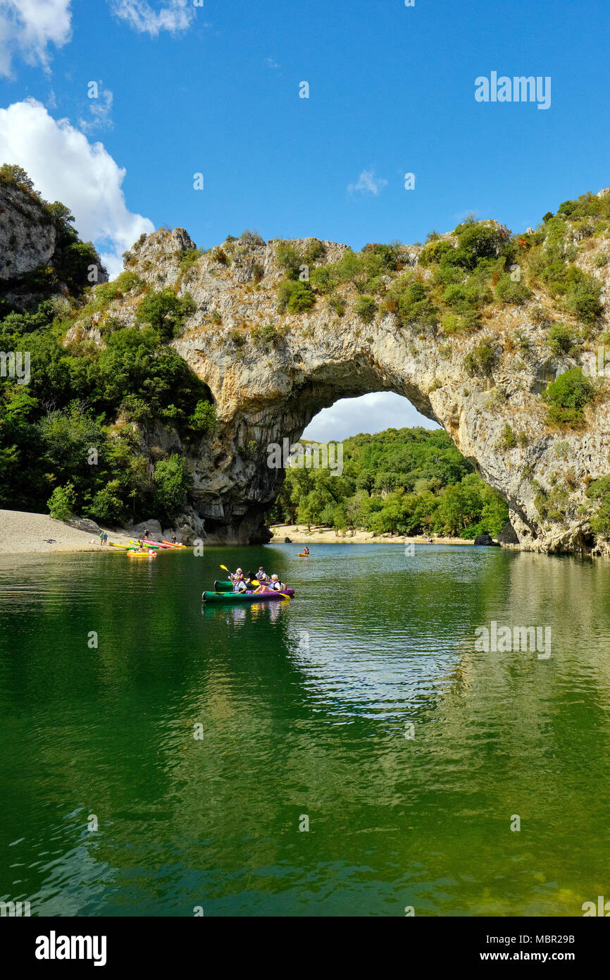 Canoë au-delà de l'arche en pierre naturelle du Pont d'Arc dans les gorges de l'Ardèche, dans le sud de la France. Banque D'Images