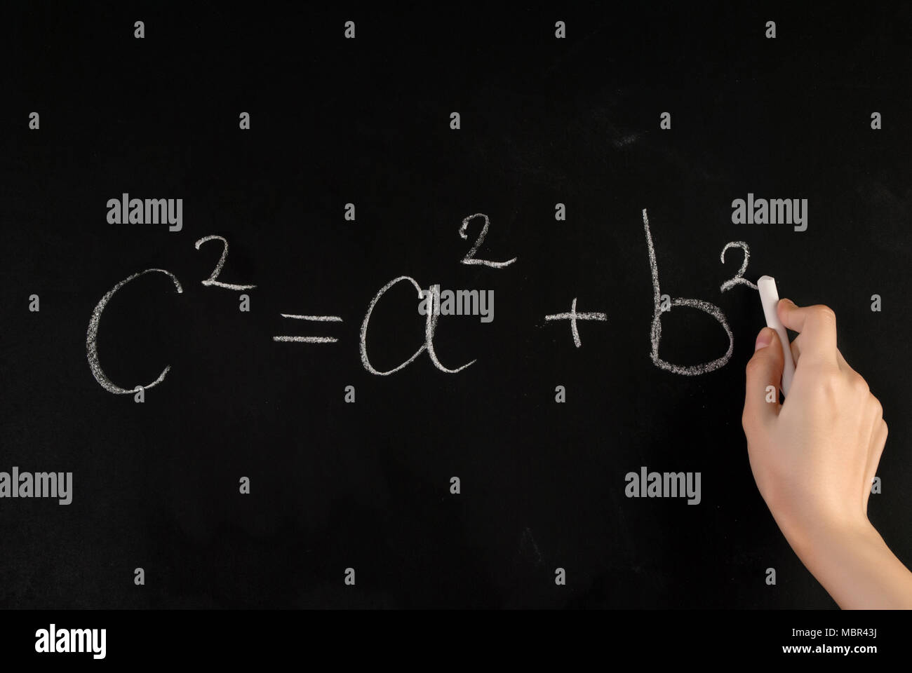 Fille main écrire théorème de Pythagore Formule sur tableau noir avec craie blanche de l'école Banque D'Images